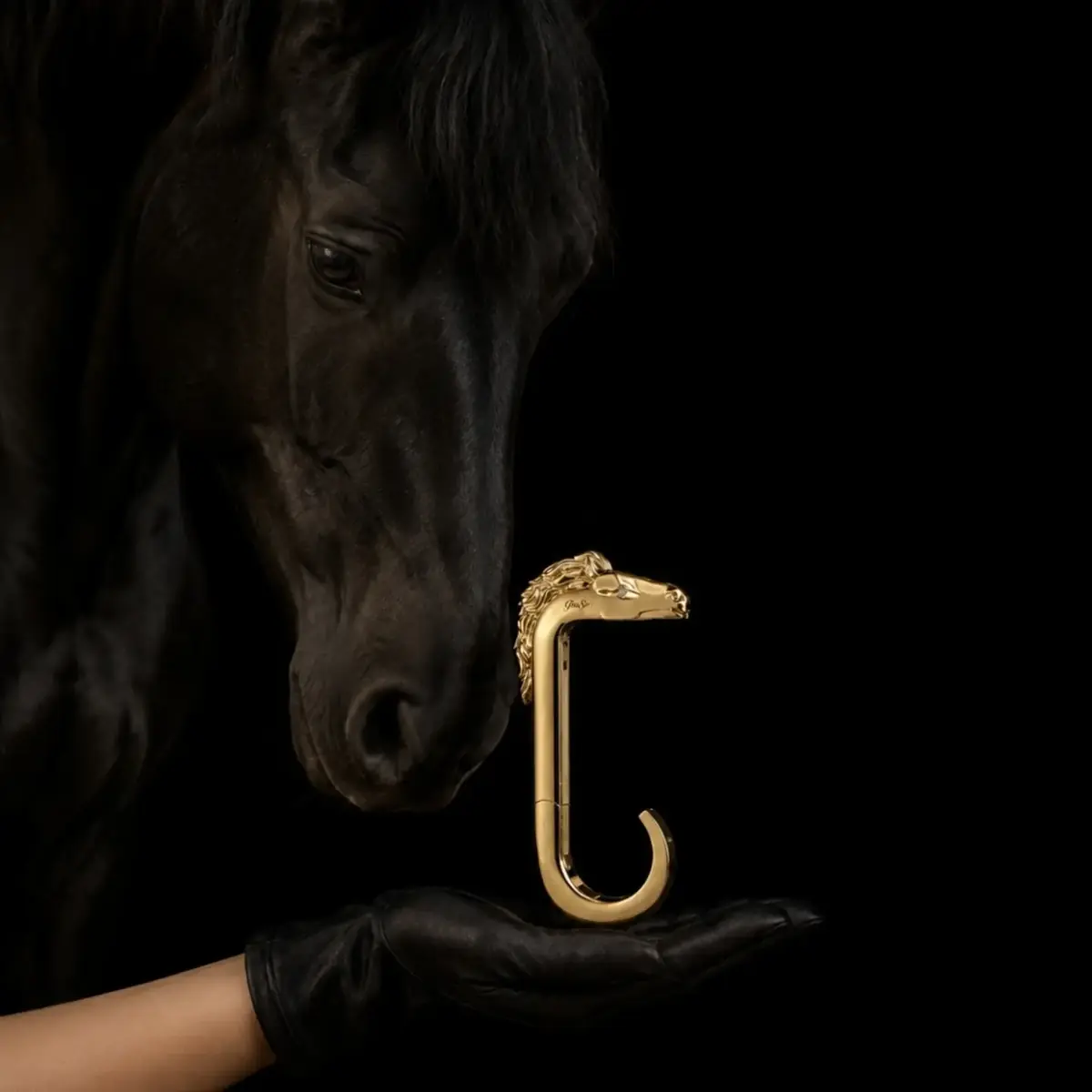 Portaborse Eleganza in oro, accanto a un cavallo nero